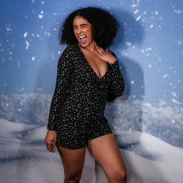 Winter-themed photo booth backdrop with guest smiling