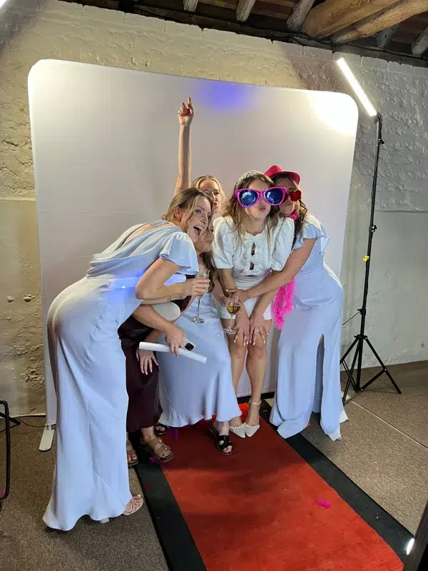 Group photo at wedding selfie booth with white backdrop